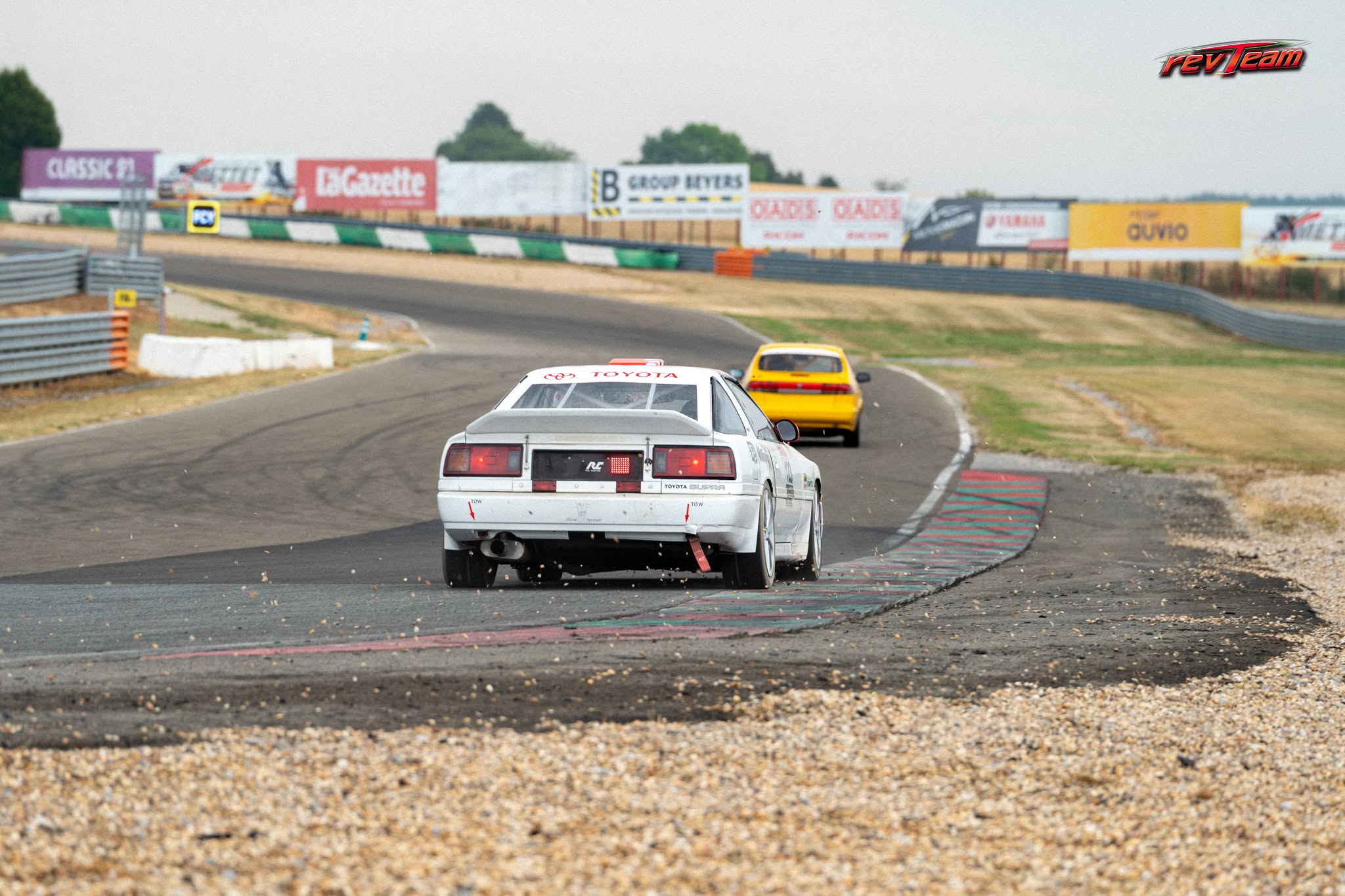 De Supra volgt een gele racewagen over het circuit