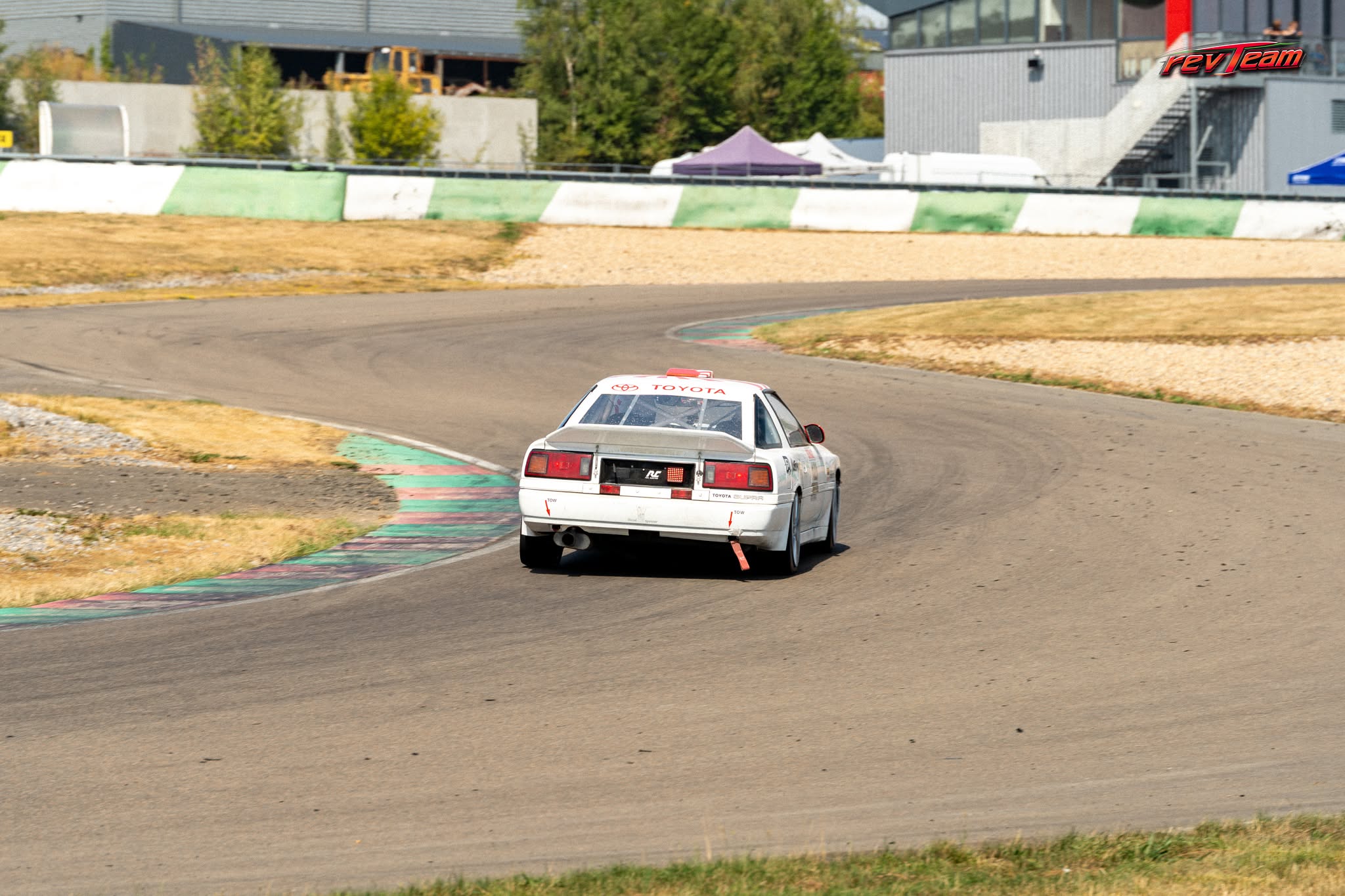 Achteraanzicht van de Toyota Supra bij het uitkomen van een bocht